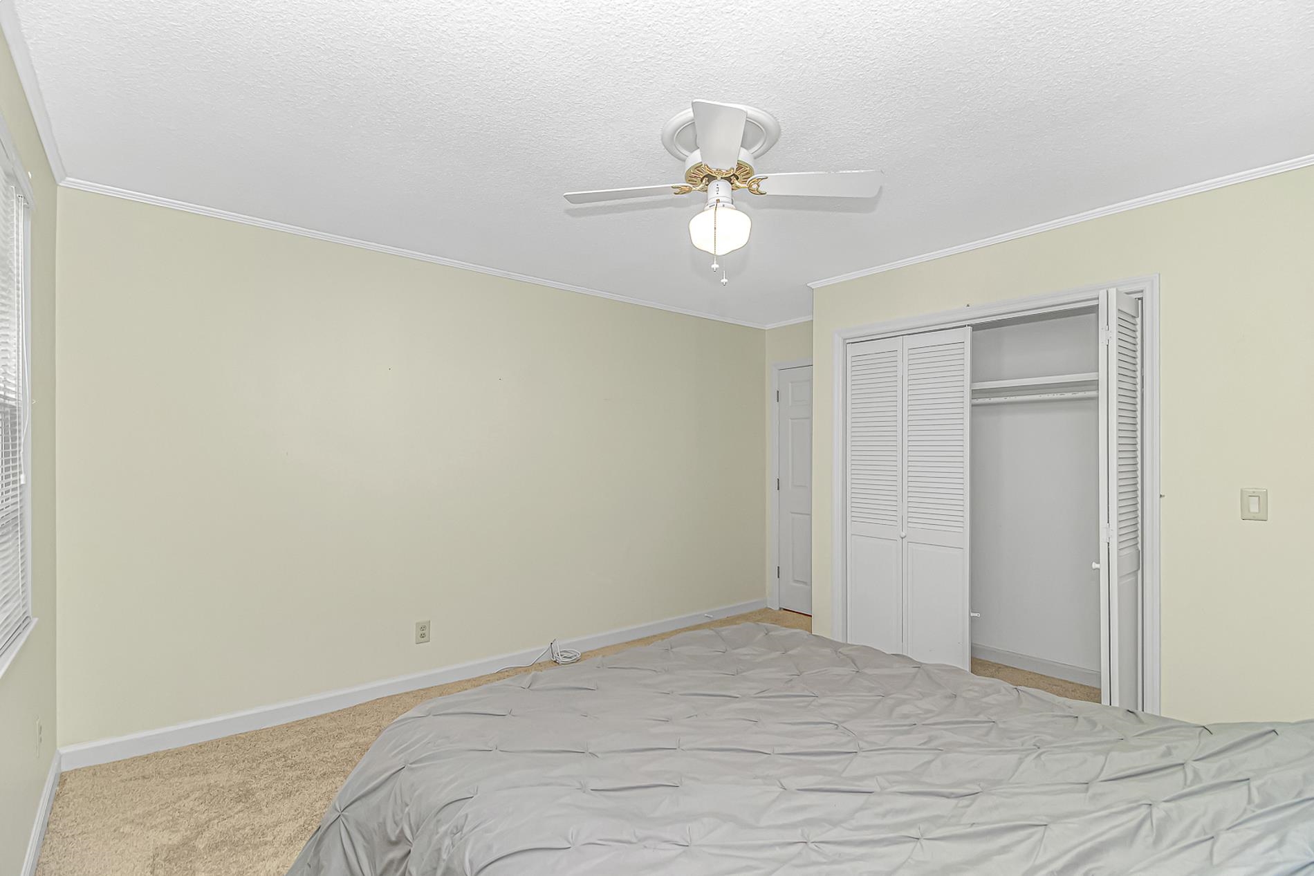 119 University Circle Conway, SC 29526 - Photo 26 of 40 Bedroom with carpet floors, ceiling fan, crown molding, a closet, and a textured ceiling