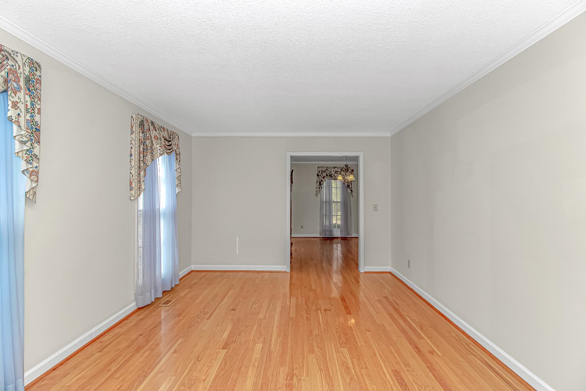 119 University Circle Conway, SC 29526 - Photo 4 of 40 Spare room featuring wood finished floors, ornamental molding, a textured ceiling, and a chandelier