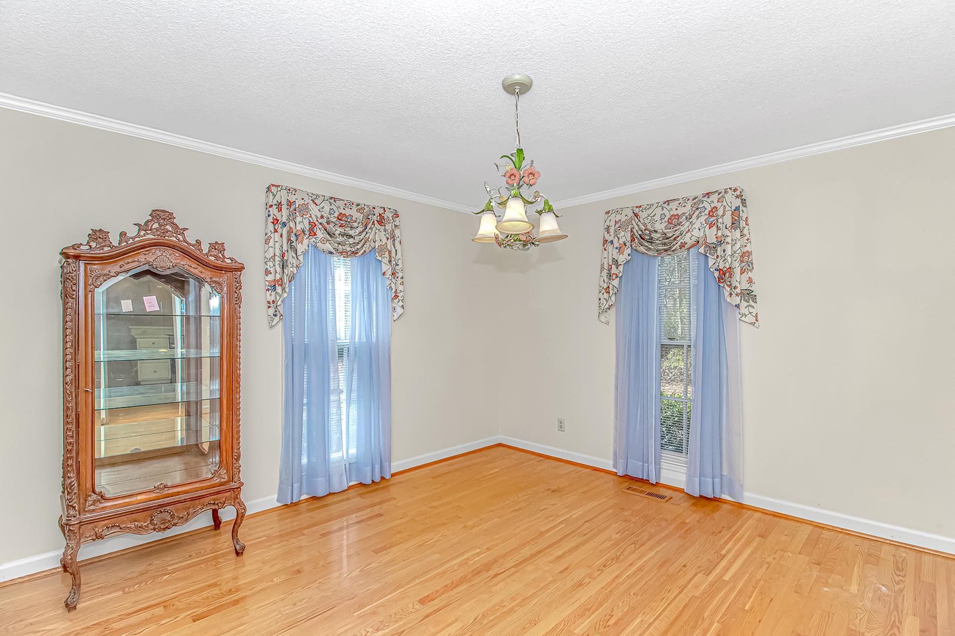 119 University Circle Conway, SC 29526 - Photo 6 of 40 Unfurnished room featuring light wood-style floors, a chandelier, crown molding, and a textured ceiling