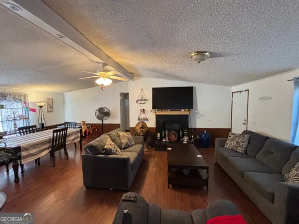 a living room with furniture and a flat screen tv with wooden floor