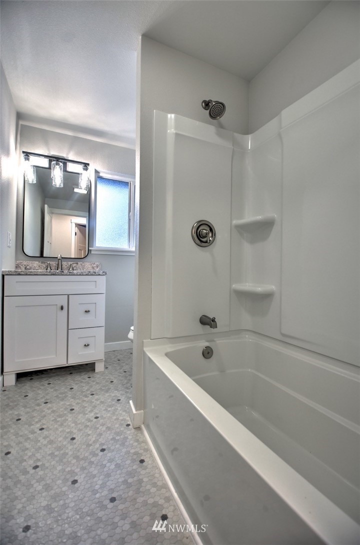 10330 185th Avenue Southwest Rochester, WA 98579 - Photo 22 of 22 a bathroom with a bathtub a mirror a vanity and a shower