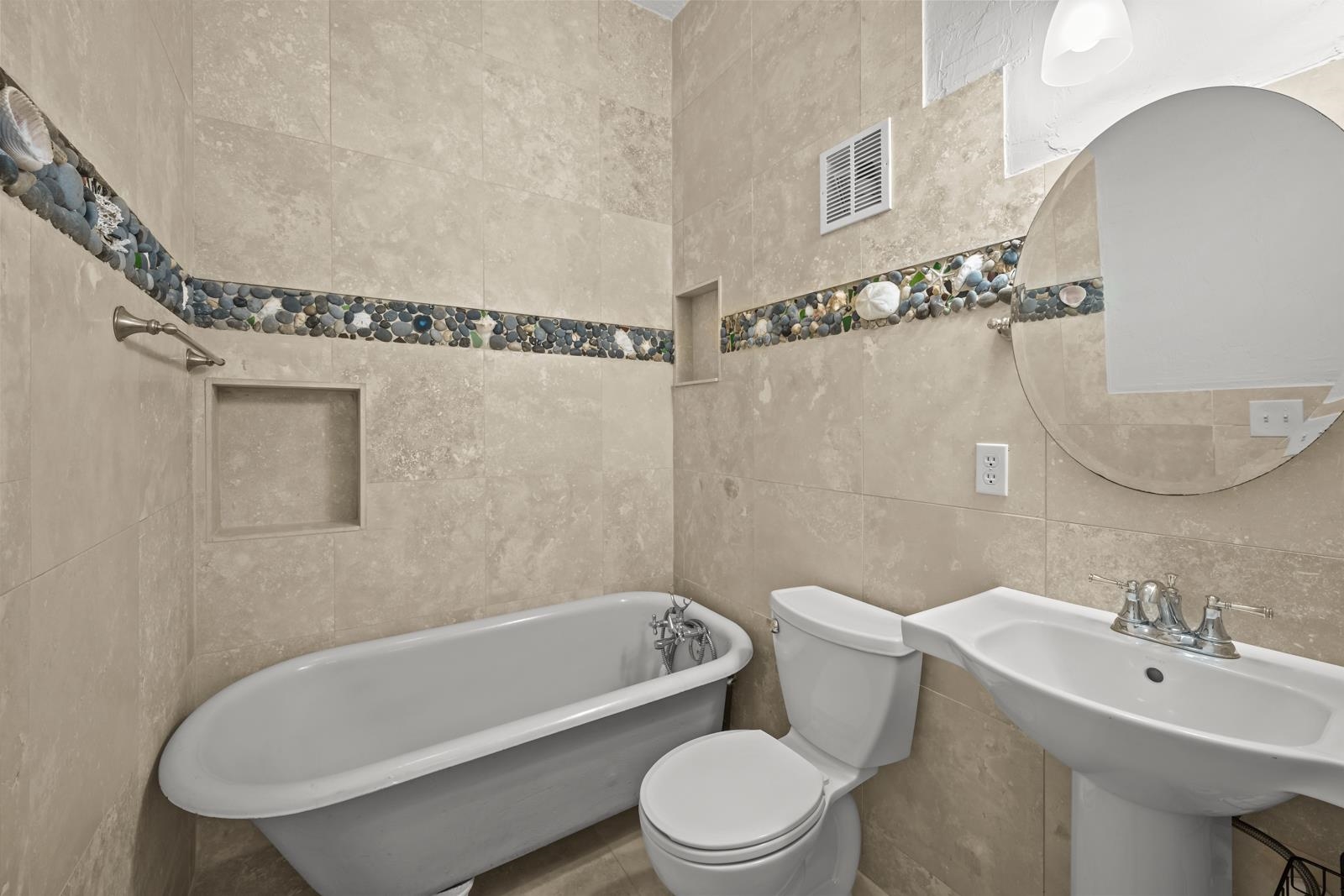 9224 July Lane St. Augustine, FL 32080 - Photo 30 of 88 a bathroom with a toilet a sink a mirror and bathtub