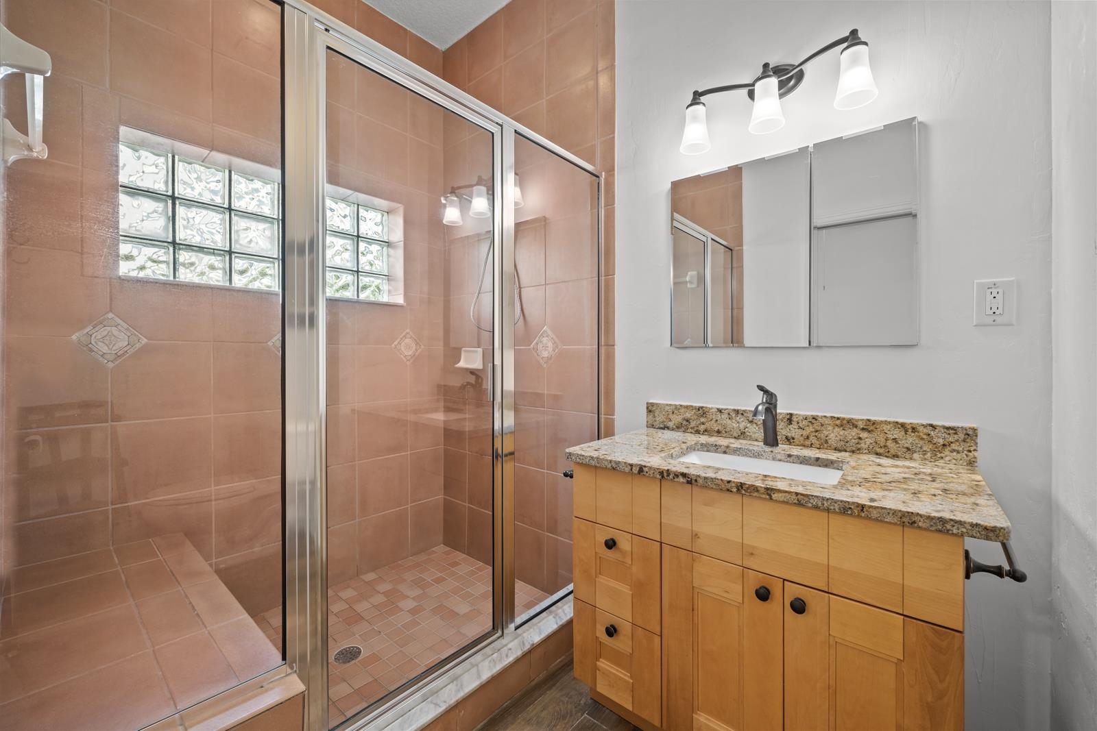 9224 July Lane St. Augustine, FL 32080 - Photo 32 of 88 a bathroom with a granite countertop sink a mirror and shower