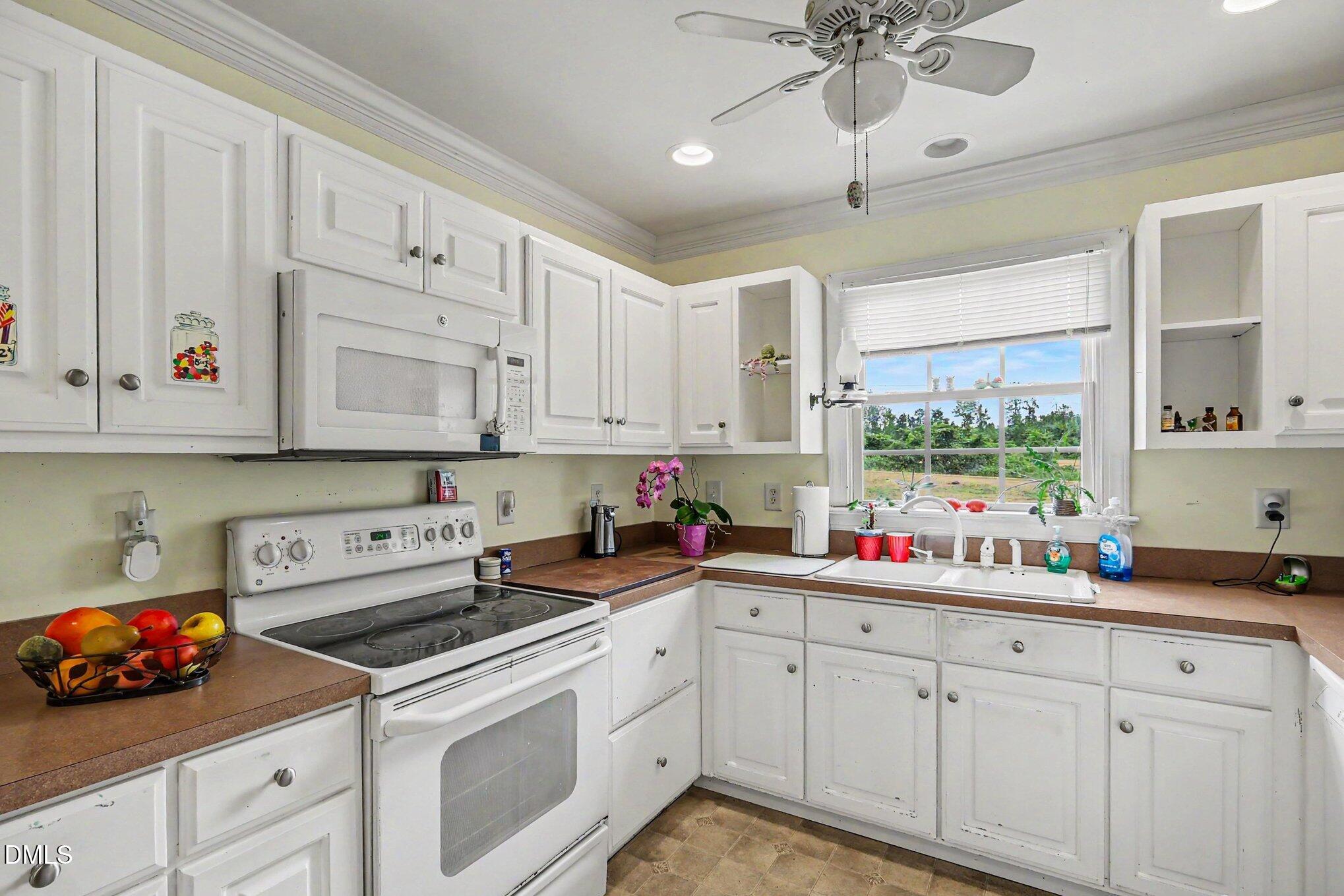 1750 Tom Oakley Road Timberlake, NC 27583 - Photo 10 of 31 a kitchen with white cabinets and white appliances