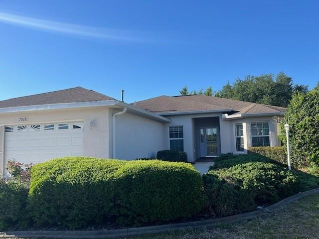 7928 Southwest 80th Pl Road Ocala, FL 34476 - Photo 2 of 30 a front view of a house with a garden