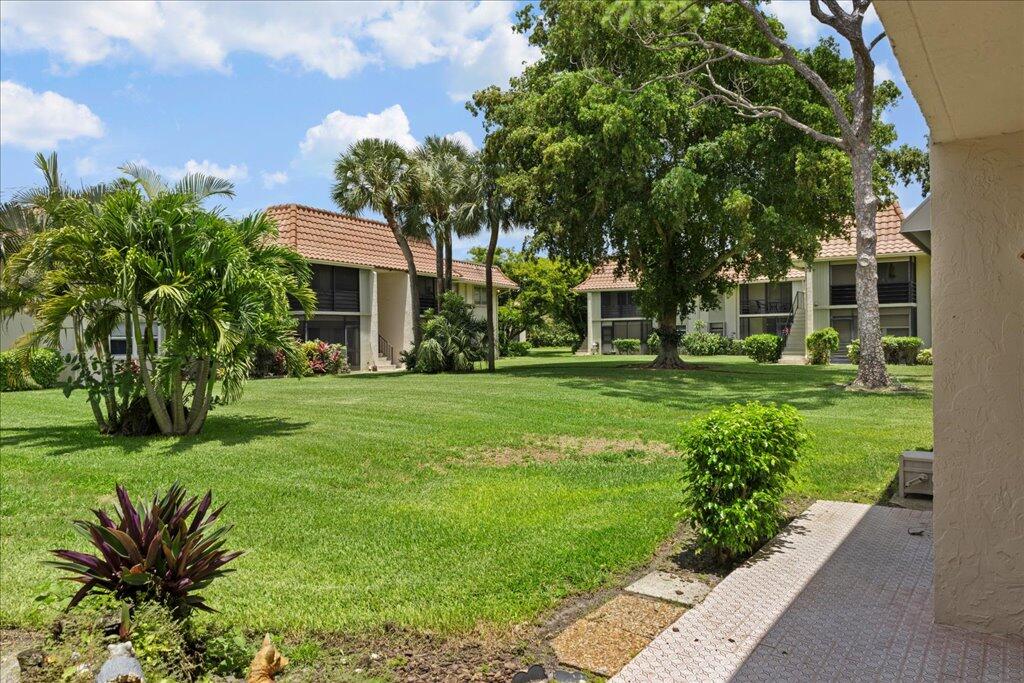 1124 Northwest 13th Street, Unit 120A Boca Raton, FL 33486 - Photo 17 of 23 a front view of a house with a yard