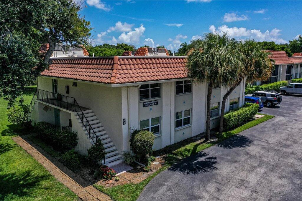 1124 Northwest 13th Street, Unit 120A Boca Raton, FL 33486 - Photo 2 of 23 a front view of a house with a garden