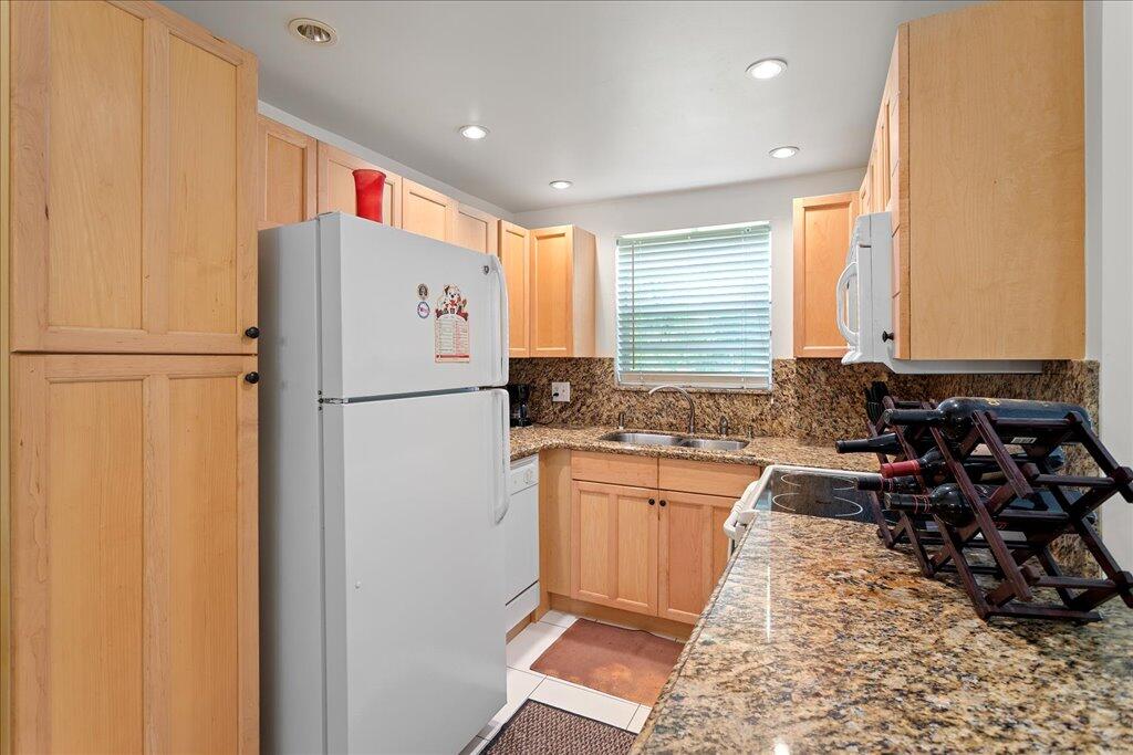 1124 Northwest 13th Street, Unit 120A Boca Raton, FL 33486 - Photo 3 of 23 a kitchen with granite countertop a refrigerator and a sink