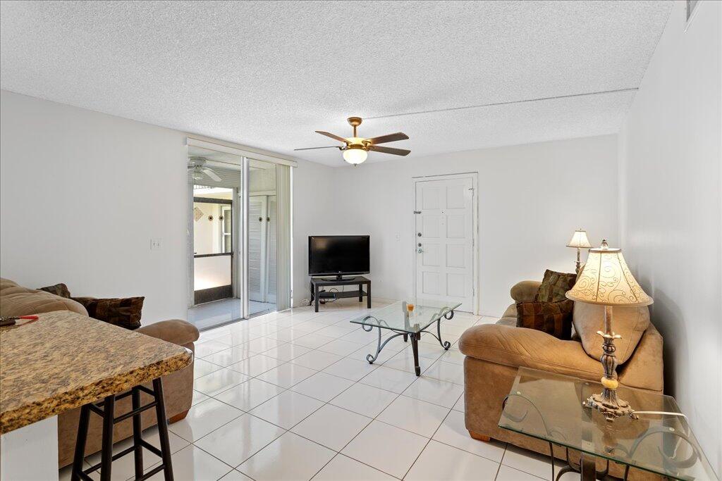 1124 Northwest 13th Street, Unit 120A Boca Raton, FL 33486 - Photo 5 of 23 a living room with furniture and a flat screen tv