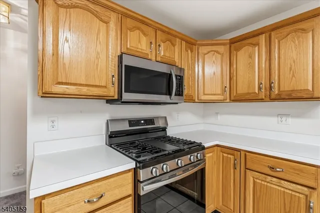 a kitchen with stainless steel appliances wooden cabinets and a stove top oven