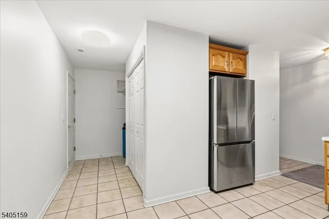 a view of a refrigerator in kitchen and empty room
