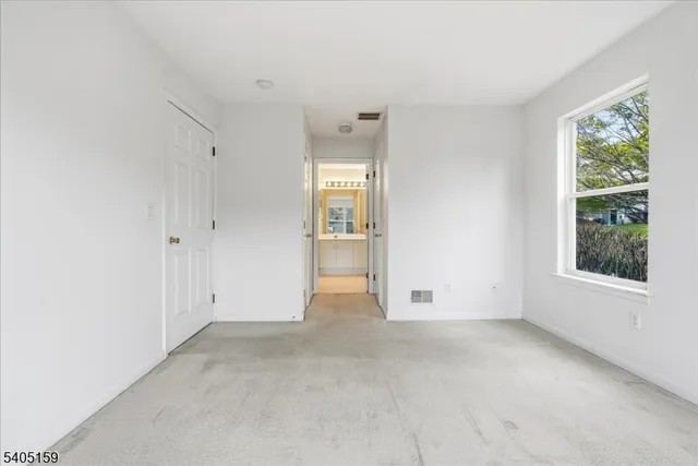 an empty room with windows and closet