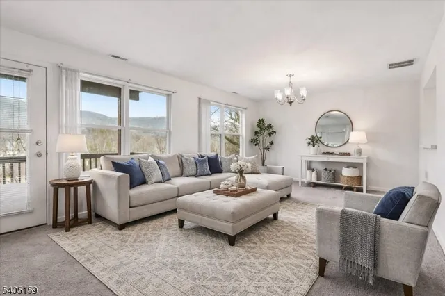 a living room with furniture a large window and a chandelier