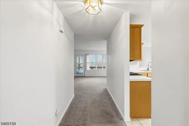 a view of a hallway to a livingroom with furniture