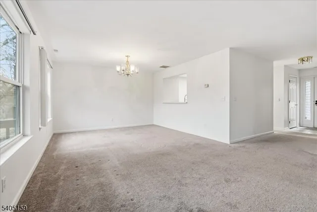 a view of a big room with windows and chandelier fan
