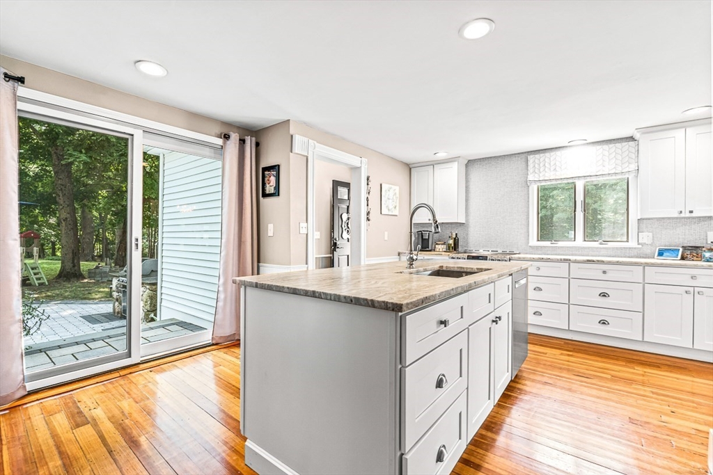 a large kitchen with granite countertop a large window and a sink