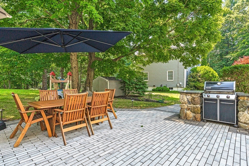 69 Maple Street Middleton, MA 01949 - Photo 26 of 33 a view of a backyard with table and chairs under an umbrella