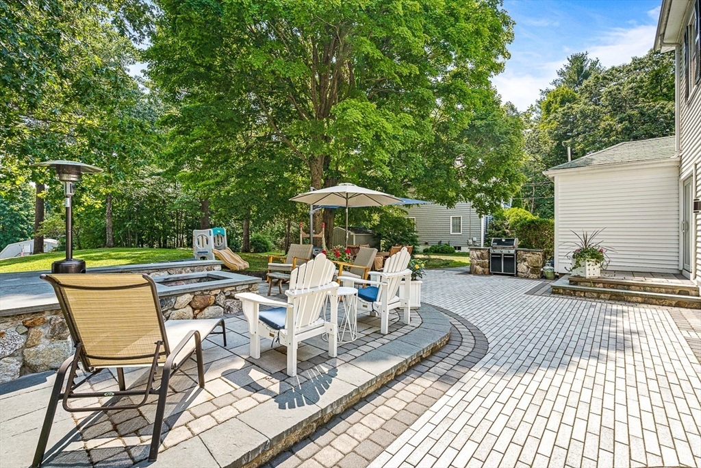 69 Maple Street Middleton, MA 01949 - Photo 29 of 33 a view of a patio with a table and chairs under an umbrella