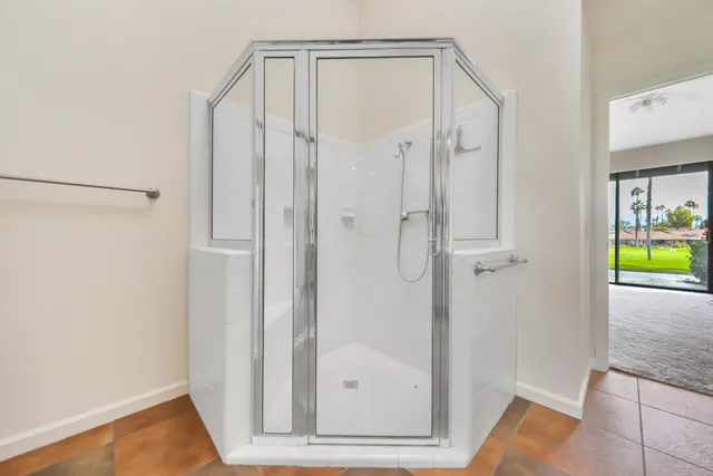 a view of an empty room with a chandelier fan