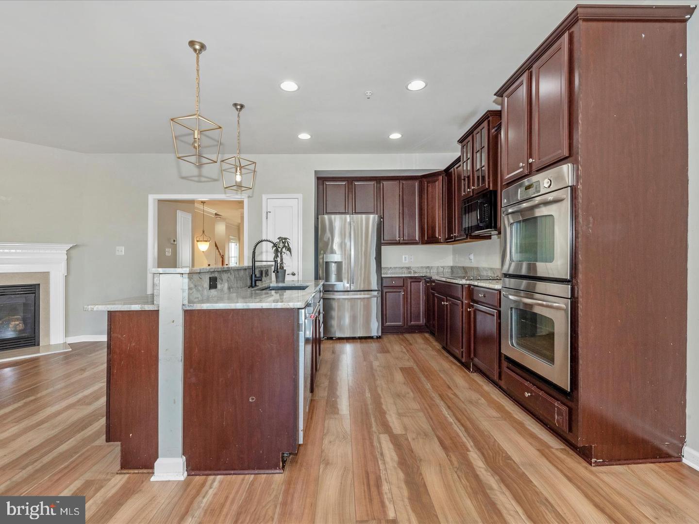 208 B Mill Pond Road Frederick, MD 21701 - Photo 11 of 45 a kitchen with stainless steel appliances granite countertop a refrigerator a sink dishwasher a stove and a oven with wooden floor
