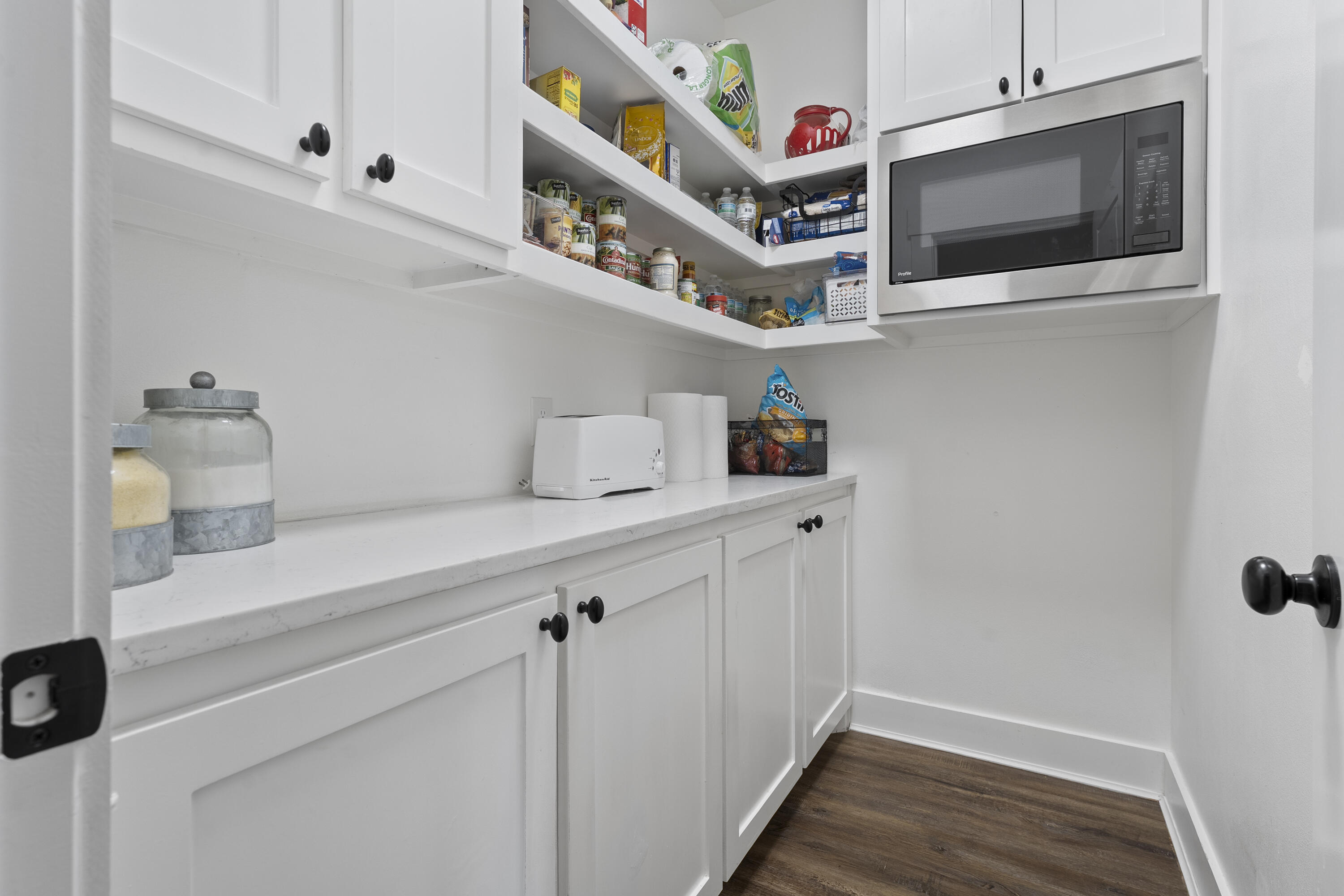 1122 16th Street Shallowater, TX 79363 - Photo 12 of 32 a hallway with white cabinets and wooden floor