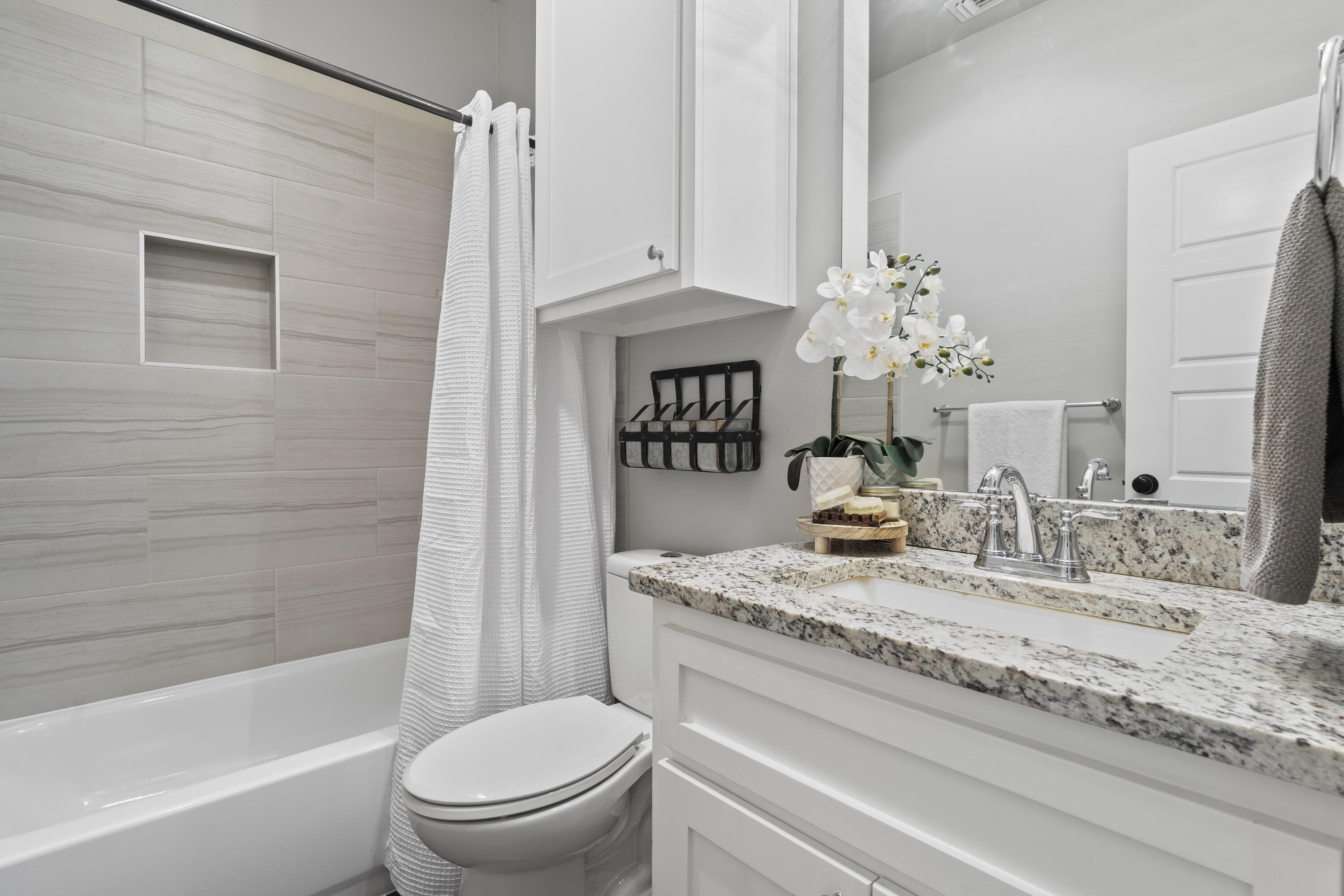 1122 16th Street Shallowater, TX 79363 - Photo 22 of 32 a bathroom with a granite countertop sink a toilet and shower