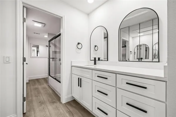 a spacious bathroom with a double vanity sink and mirror
