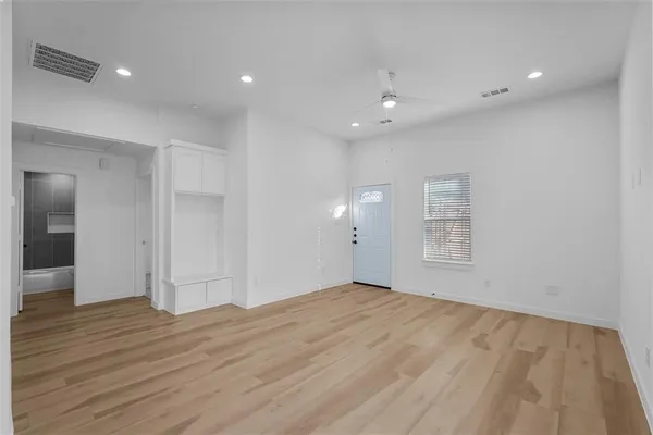 an empty room with wooden floor and windows