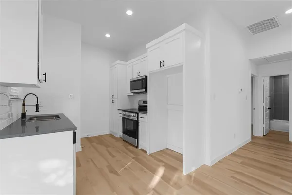a kitchen with granite countertop a sink stove and refrigerator