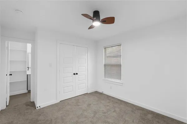 an empty room with closet and windows