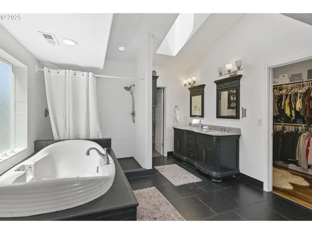 a bathroom with a tub sink and mirror