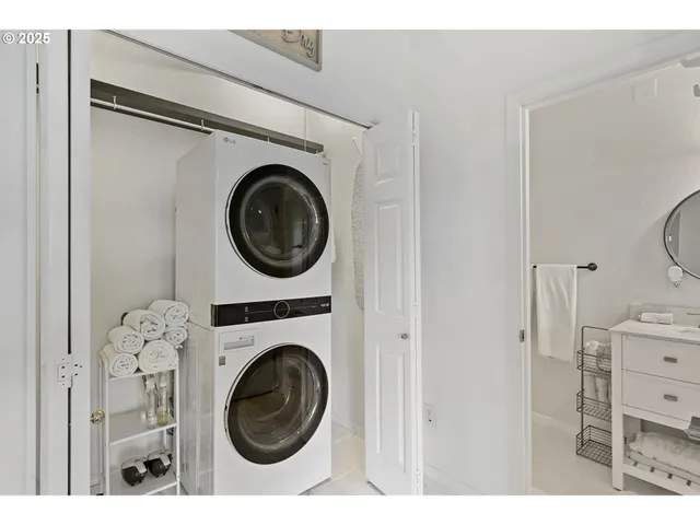a utility room with dryer washer and a view of bathroom