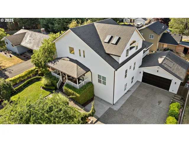a view of a white house with a big yard and large trees