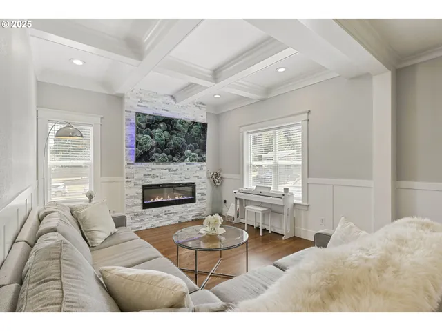 a living room with furniture a large window and a fireplace