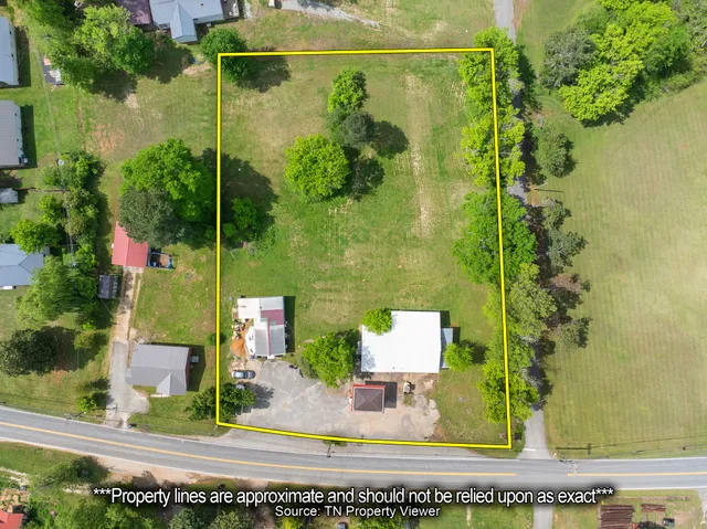 an aerial view of a residential houses with yard