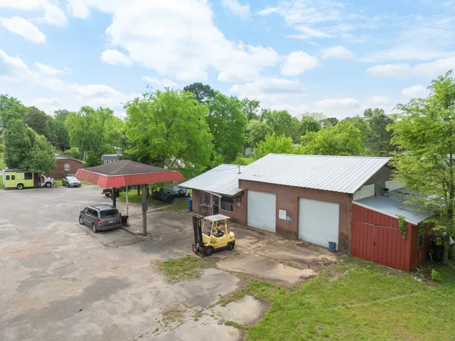 a yellow and red and white house with a yard and fence
