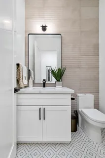 a bathroom with a sink a toilet a mirror and vanity