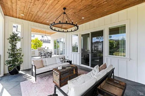 a living room with patio furniture and a chandelier