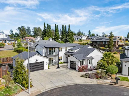 a aerial view of a house with a big yard and large trees