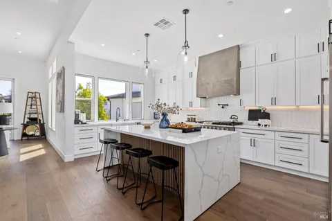 a kitchen with appliances a sink a counter top space and a center island