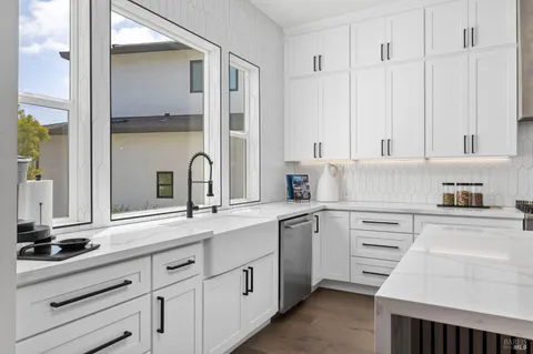 a kitchen with granite countertop white cabinets and white appliances