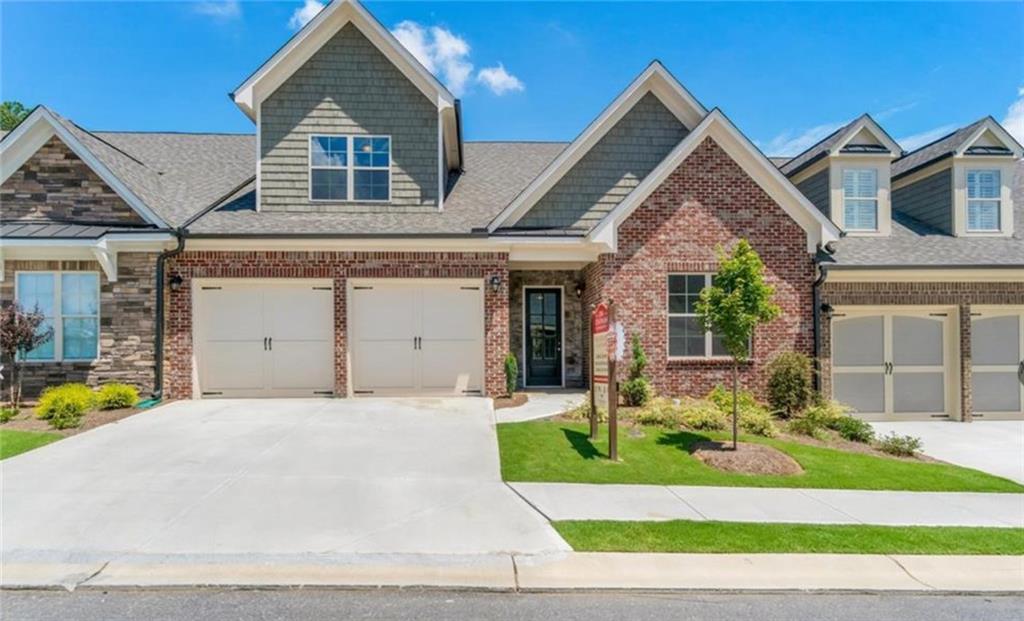5610 Ansley Ridge Lane, Unit 76 Suwanee, GA 30024 - Photo 1 of 1 a front view of a house with a yard outdoor seating and garage