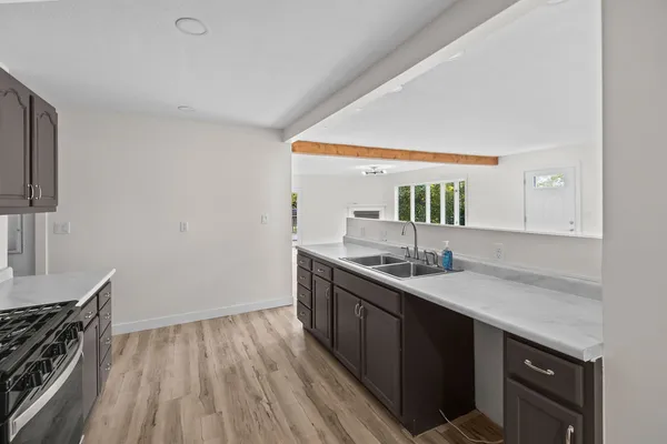 a kitchen with a sink and stove top oven