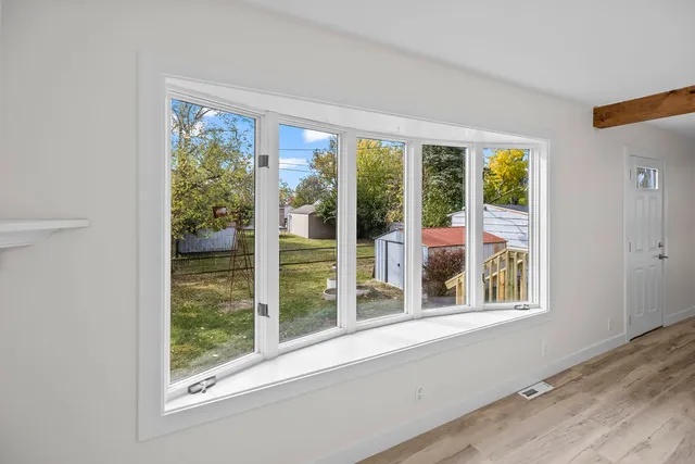 a view of a room that has a large window and front door