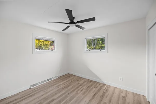 a view of empty room with wooden floor
