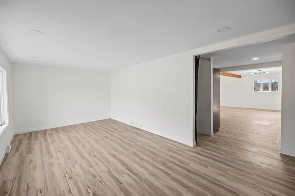 a view of empty room with wooden floor