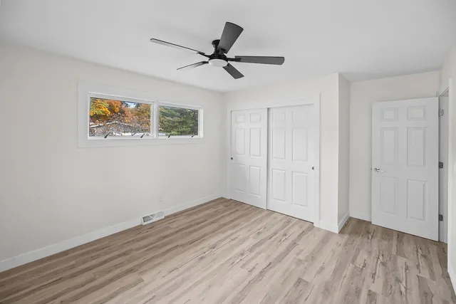 a view of room with wooden floor and ceiling fan