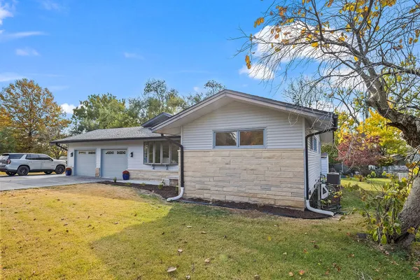 a front view of house with yard and trees in the background