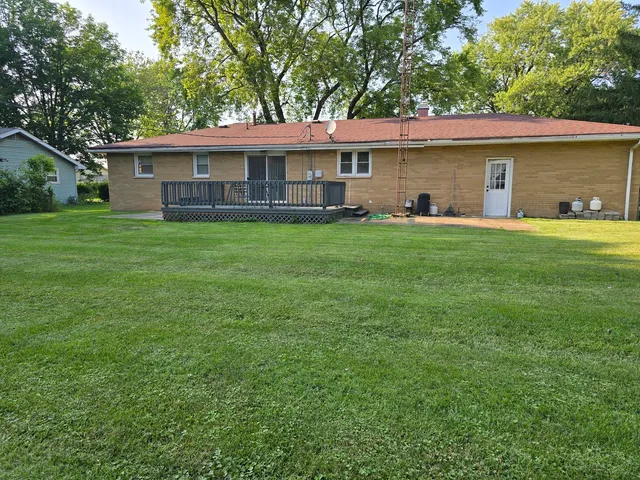 a view of a yard in front of a house with large windows