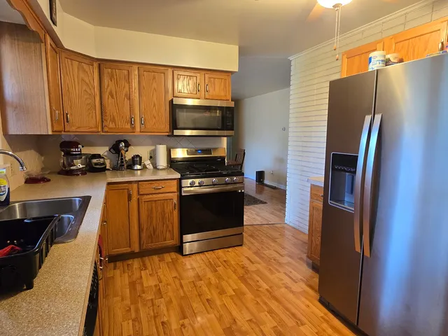 a kitchen with stainless steel appliances a refrigerator a stove a sink and a cabinets